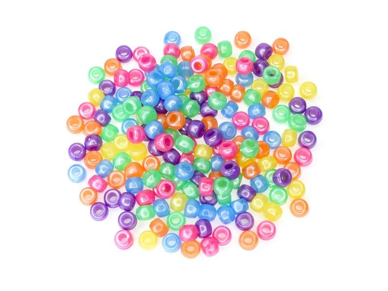 Pile of 6 x 9mm plastic pony beads in pastel pearl colours on a white background