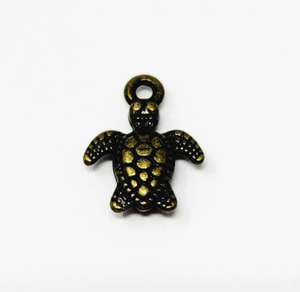 Close-up of a bronze-tone 10 x 13mm turtle pendant with a dotted shell and top loop