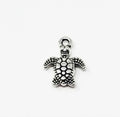 Close-up of a silver-tone 10 x 13mm turtle pendant with a dotted shell and top loop