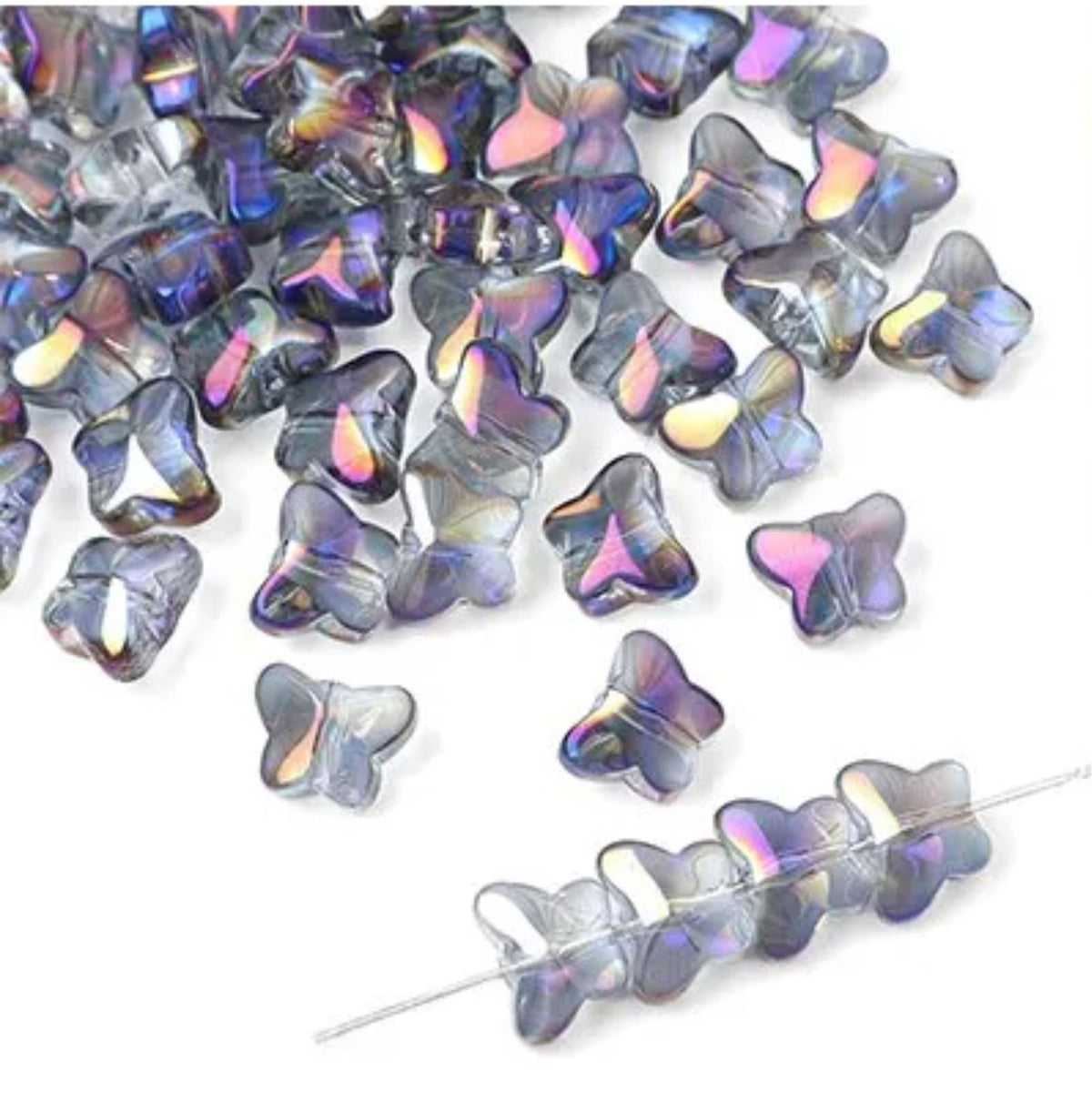 Iridescent glass butterfly beads in blue, purple and gold tones, some strung