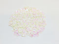 Pile of 6mm round buttercream sequins with centre holes, on a white background