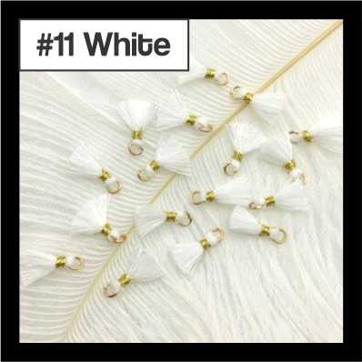 Scattered 1cm white cotton tassels with gold-tone rings on white fur, labelled #11