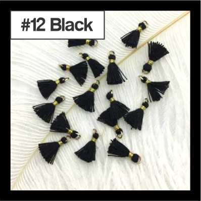 Scattered 1cm black cotton tassels with gold-tone rings on white fur, labelled #12