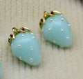 Close-up of 13 x 19mm turquoise acrylic strawberry charms dotted with tiny pearls, with gold-tone leaf caps
