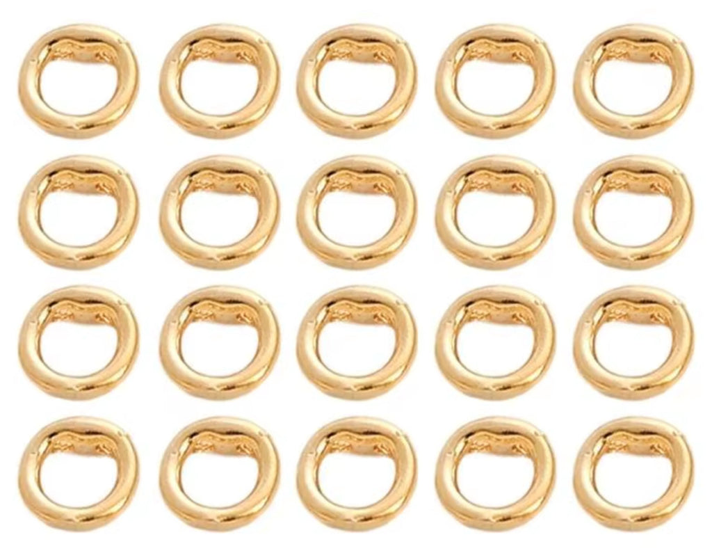 Grid of 20 14K gold double-hole connector rings, arranged in rows on a white background
