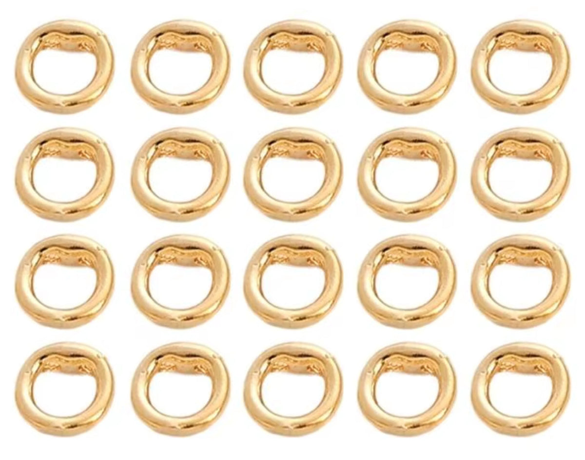 Grid of 20 14K gold double-hole connector rings, arranged in rows on a white background
