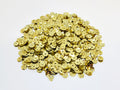 Pile of 6mm round gold sequins with centre holes, on a white background