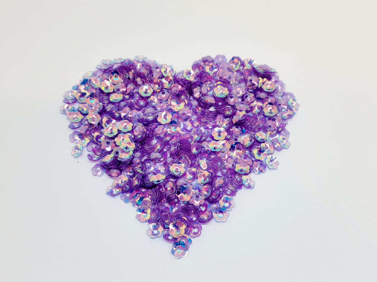 Heart-shaped pile of 6mm iridescent flower sequins in violet