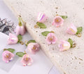Pink 15mm bell flower beads with green leaf caps scattered with pink petals