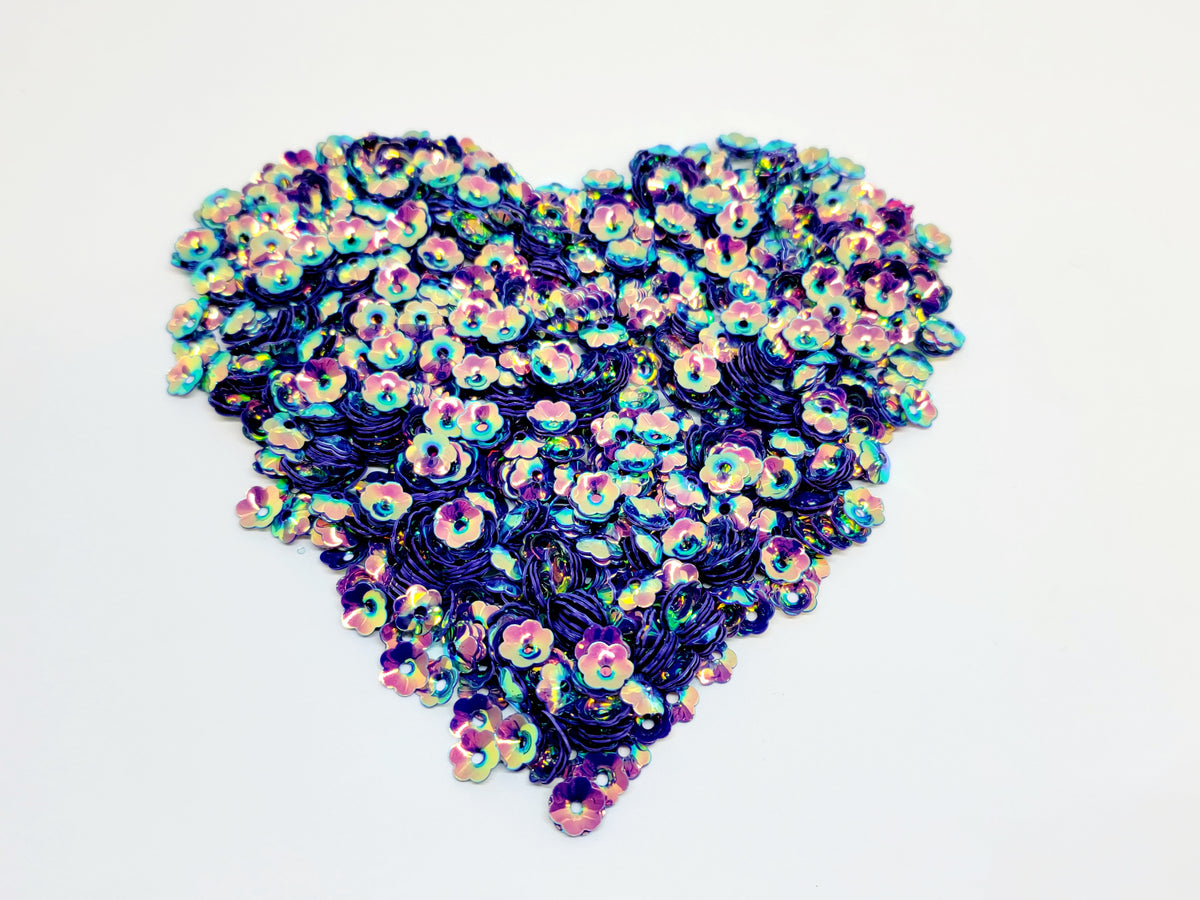 Heart-shaped pile of 6mm iridescent flower sequins in mystic purple