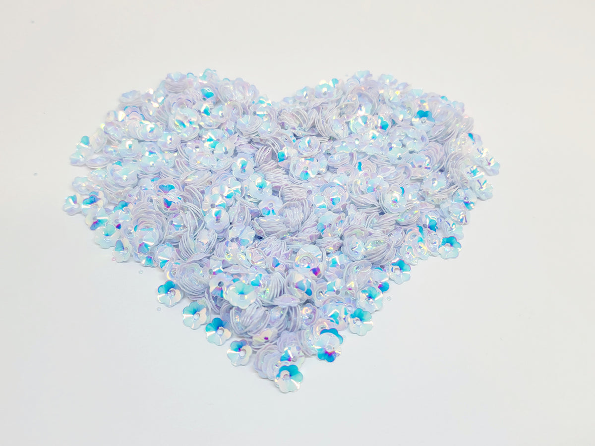 Heart-shaped pile of 6mm iridescent flower sequins in bright white