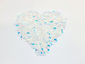 Heart-shaped pile of 6mm iridescent flower sequins in crystal white