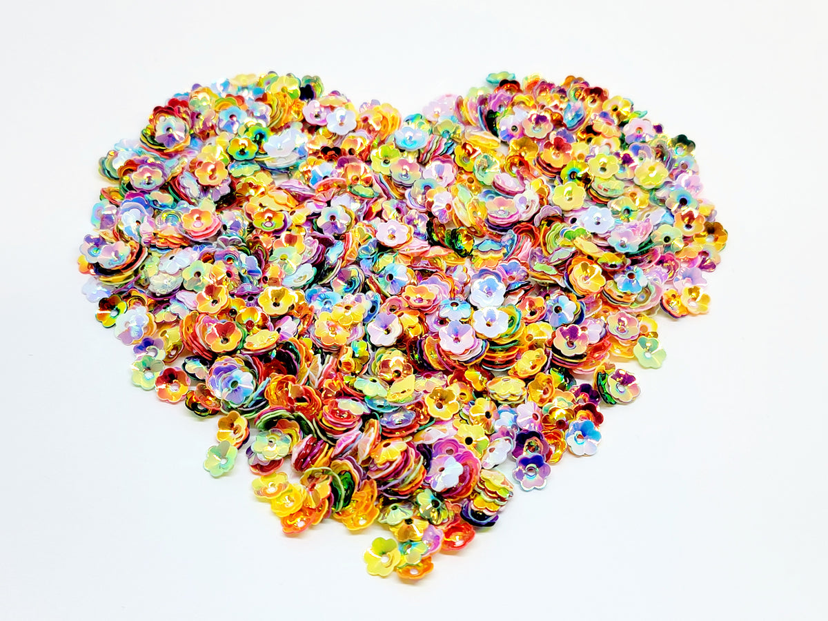 Heart-shaped pile of 6mm iridescent flower sequins in an autumn blend of orange, red, yellow and brown