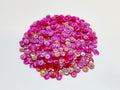 Pile of 6mm round red sequins with centre holes, on a white background