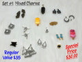 Set #1 of mixed charms on white fur, including steer skulls, pinecones, ice cream hearts, earring hoops and a rose