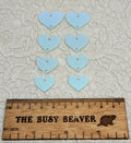Two sets of four graduated acrylic hearts in iridescent icy blue, beside a ruler