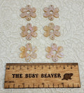 Two sets of three graduated acrylic flower pieces in apricot ripple with glitter, beside a ruler