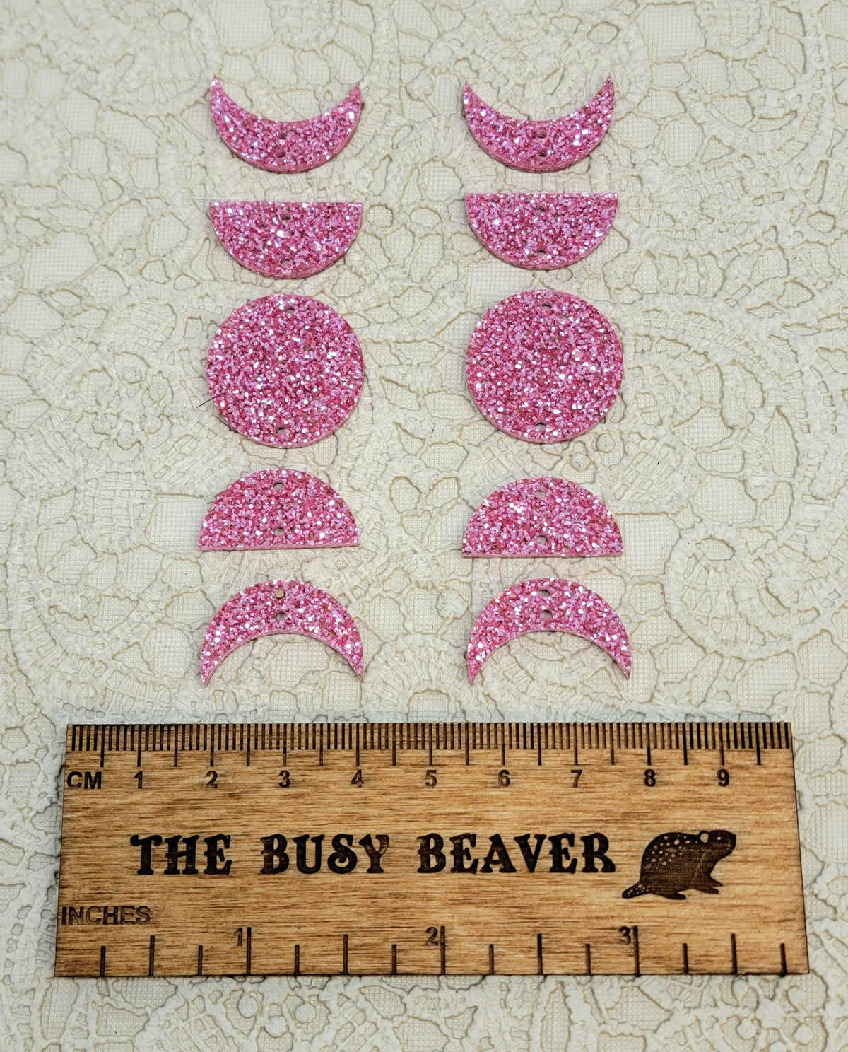Two 5-tier acrylic moon phase sets in pink glitter: crescent, half and full moons beside a ruler