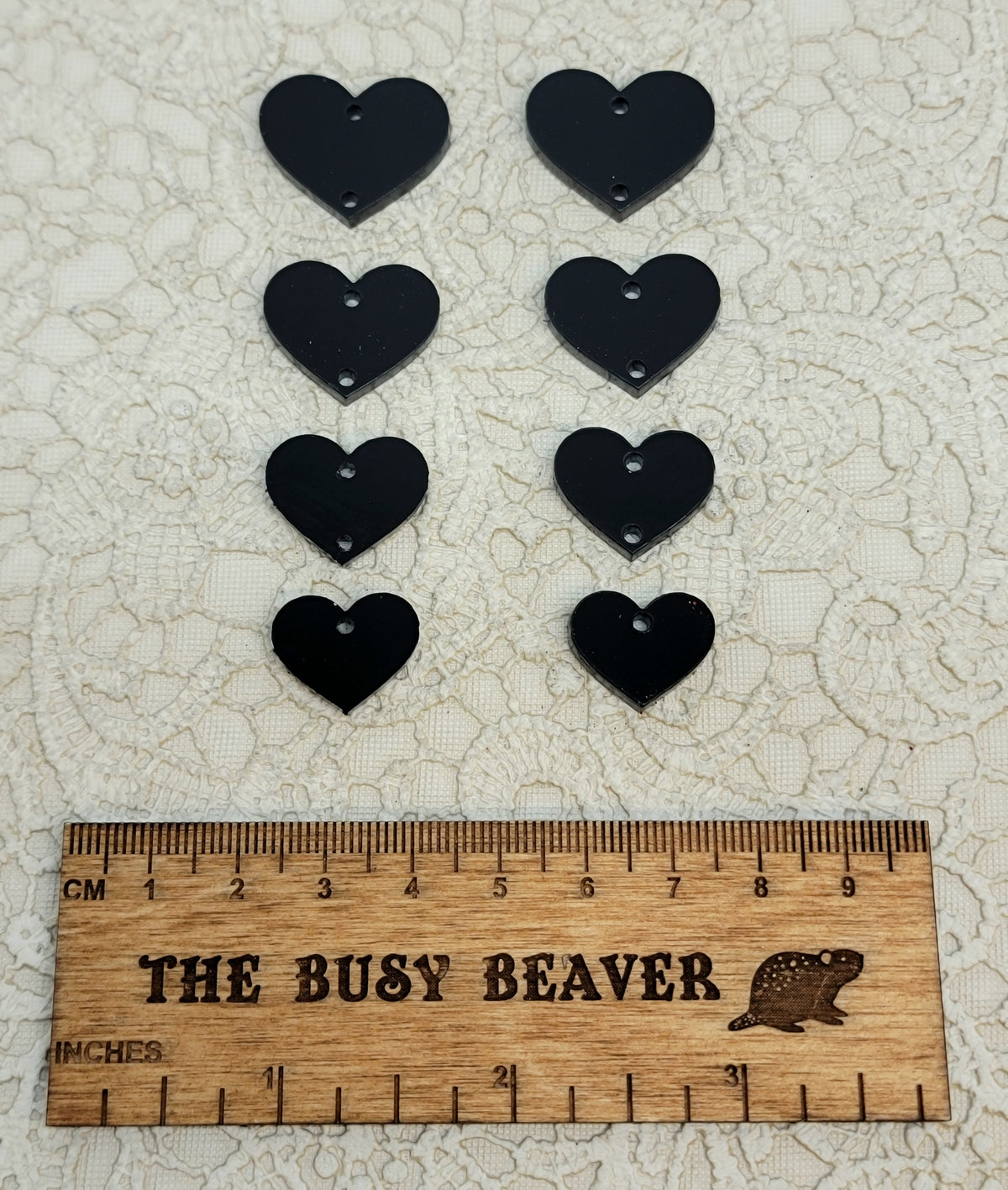 Two sets of four graduated acrylic hearts in black, beside a ruler