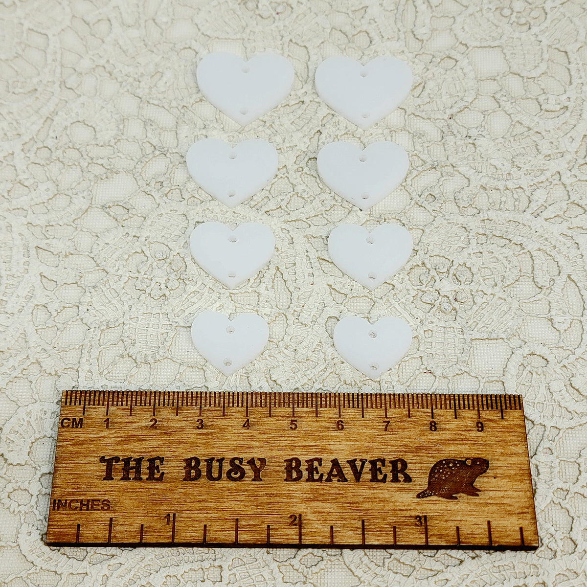 Two sets of four graduated acrylic hearts in linen, beside a ruler