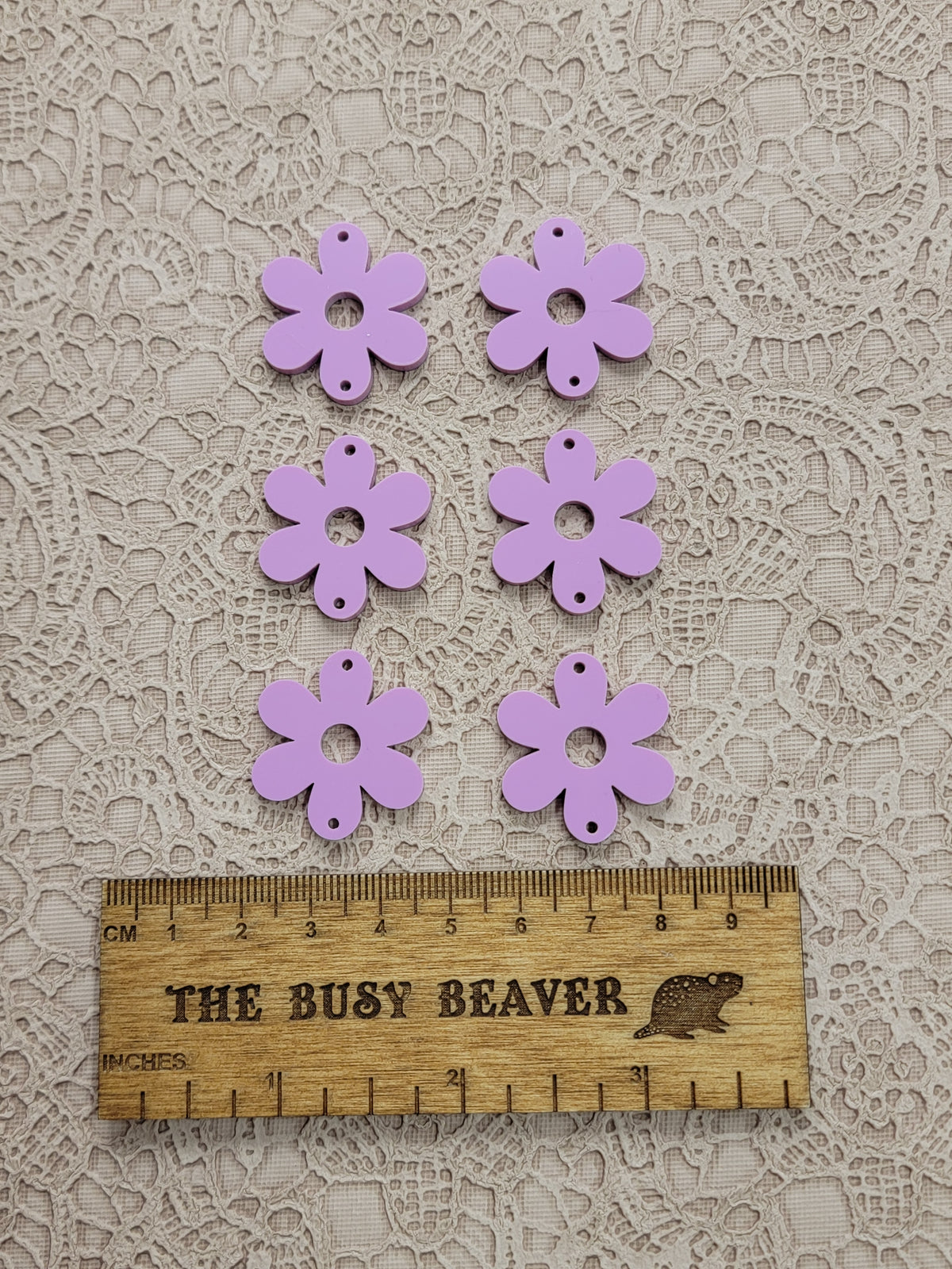 Two sets of three graduated acrylic flower pieces in dark pink pastel, beside a ruler
