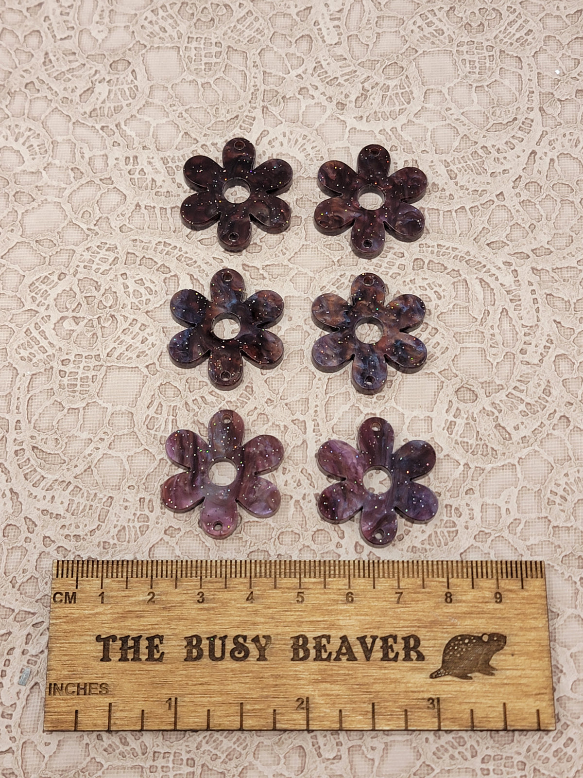 Two sets of three graduated acrylic flower pieces in brown ripple with glitter, beside a ruler