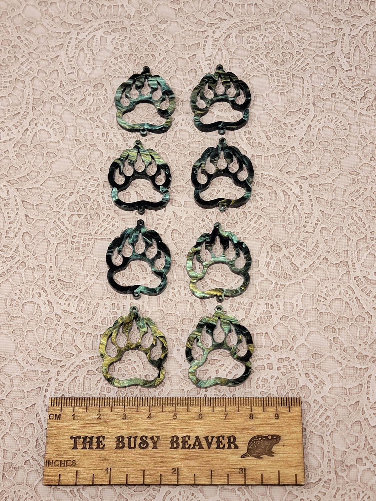 Two sets of four graduated acrylic open bear paws in black/green/gold marble, beside a ruler