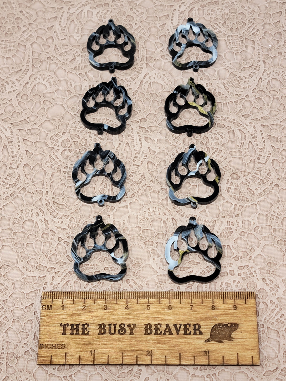 Two sets of four graduated acrylic open bear paws in black/gold/white marble, beside a ruler