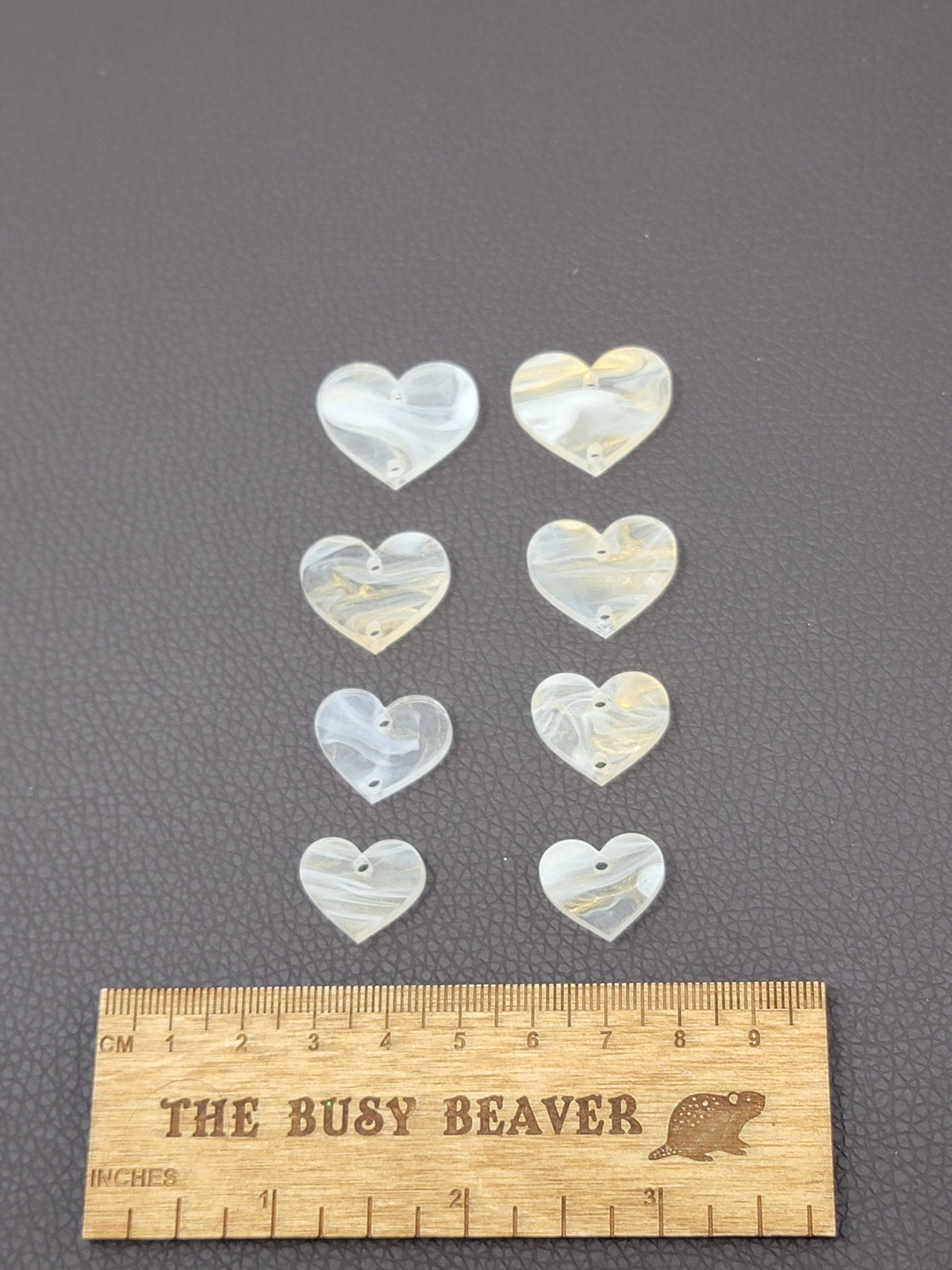 Two sets of four graduated acrylic hearts in cream/gold marble, beside a ruler