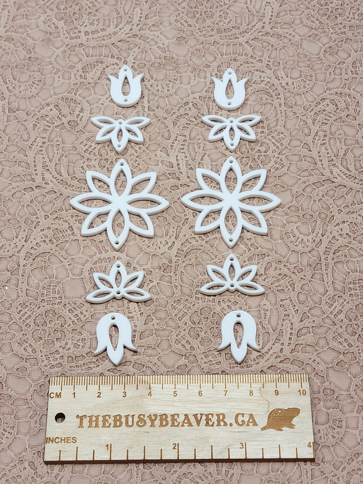 Two 5-tier acrylic flower earring sets in white, laid out top to bottom beside a ruler