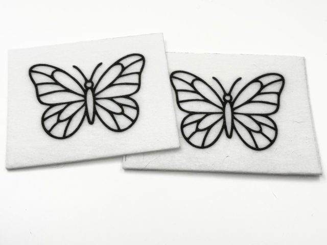 Two beading patterns printed in black on stiff white pellon squares, showing a butterfly