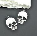 Two silver-tone 21 x 36mm skull pendants with flower eye details