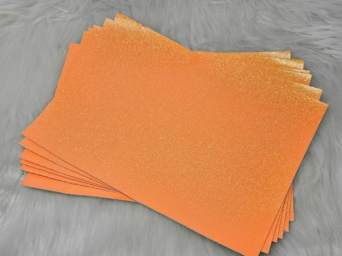 Stack of #26 orange glow-in-the-dark glitter faux leather sheets with a fine shimmer