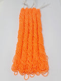 Five hanks of Preciosa 11/0 transparent neon orange seed beads laid out on a white background