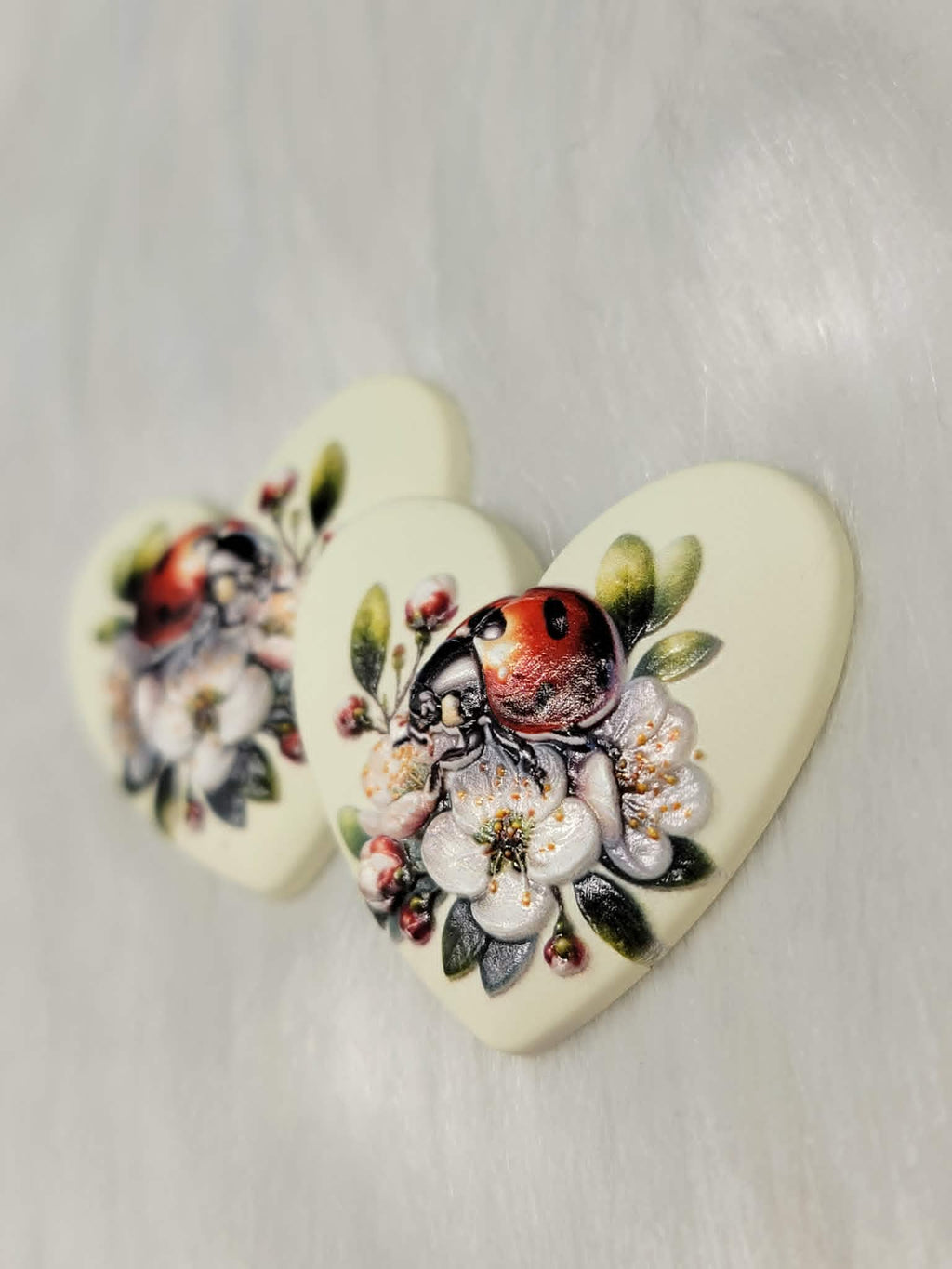 Close-up of the cream ladybug Premium 3D heart cabochons showing the ladybug and blossom detail