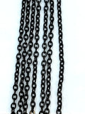 Hanging strands of 2mm black stainless steel link chain against a white background