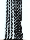 Hanging strands of 2 x 3mm black stainless steel link chain against a white background