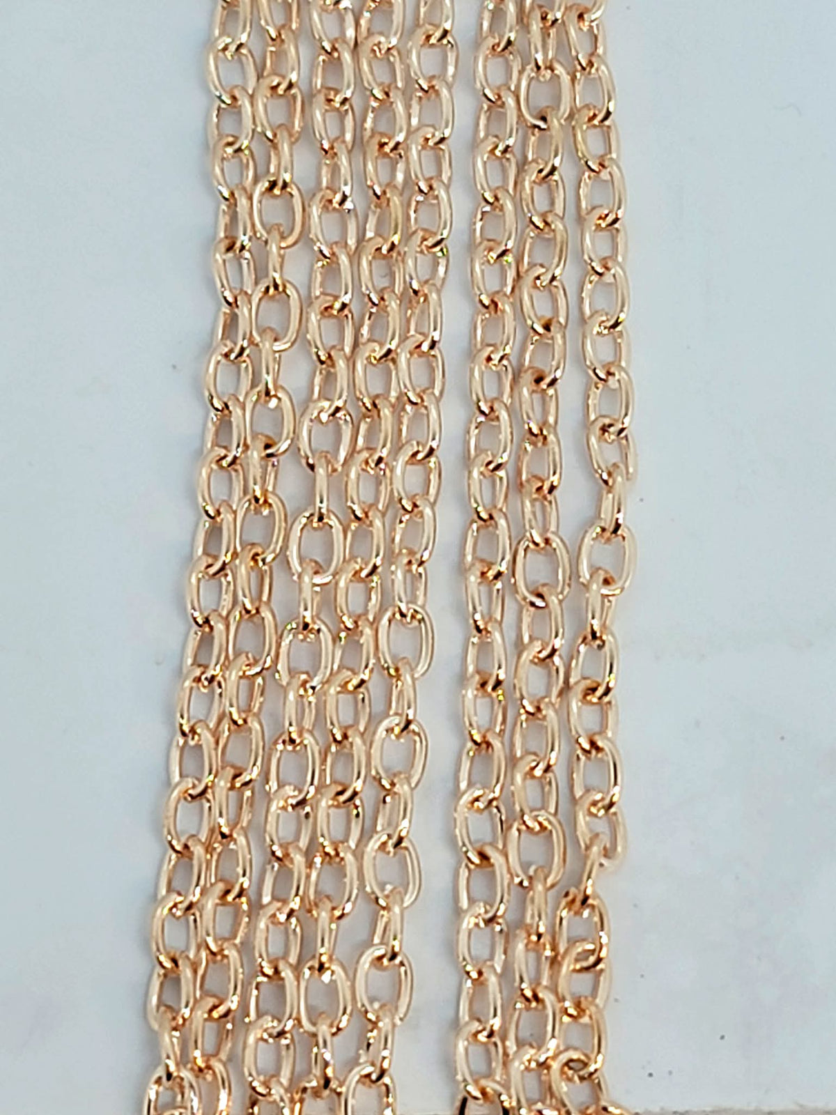 Hanging strands of 2 x 3mm rose gold stainless steel link chain