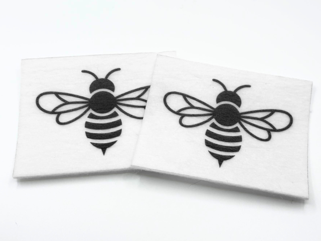 Two beading patterns printed in black on stiff white pellon squares, showing a bold striped bee