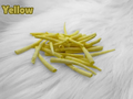 Pile of yellow dyed smooth dentalium shells, about 1.5 to 2 inches long, on white faux fur