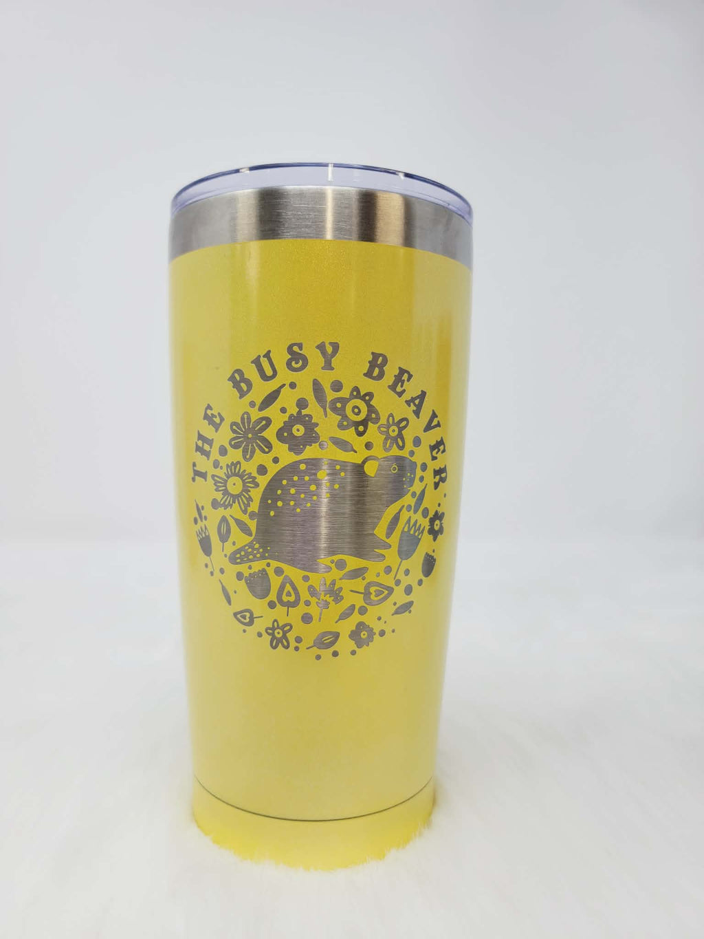 Yellow stainless steel tumbler engraved with a round floral beaver logo