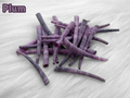 Pile of plum dyed smooth dentalium shells, about 1.5 to 2 inches long, on white faux fur