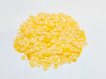 Pile of 6mm round dark yellow sequins with centre holes, on a white background