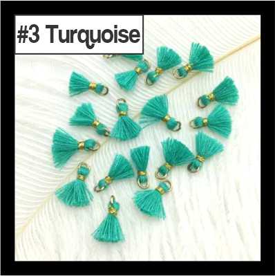 Scattered 1cm turquoise cotton tassels with gold-tone rings on white fur, labelled #3