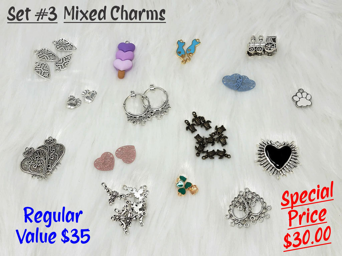 Set #3 of mixed charms on white fur, including an ice cream heart, train, paw print, filigree heart and spiked heart