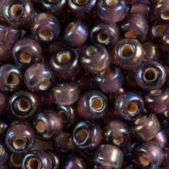 Close-up of 9mm glass crow beads in transparent purple with an iris finish
