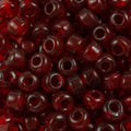 Close-up of 9mm glass crow beads in transparent ruby red, filling the frame