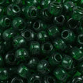 Close-up of 9mm glass crow beads in transparent forest green