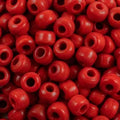 Close-up of 9mm glass crow beads in opaque red, filling the frame