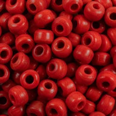 Close-up of 9mm glass crow beads in opaque red, filling the frame
